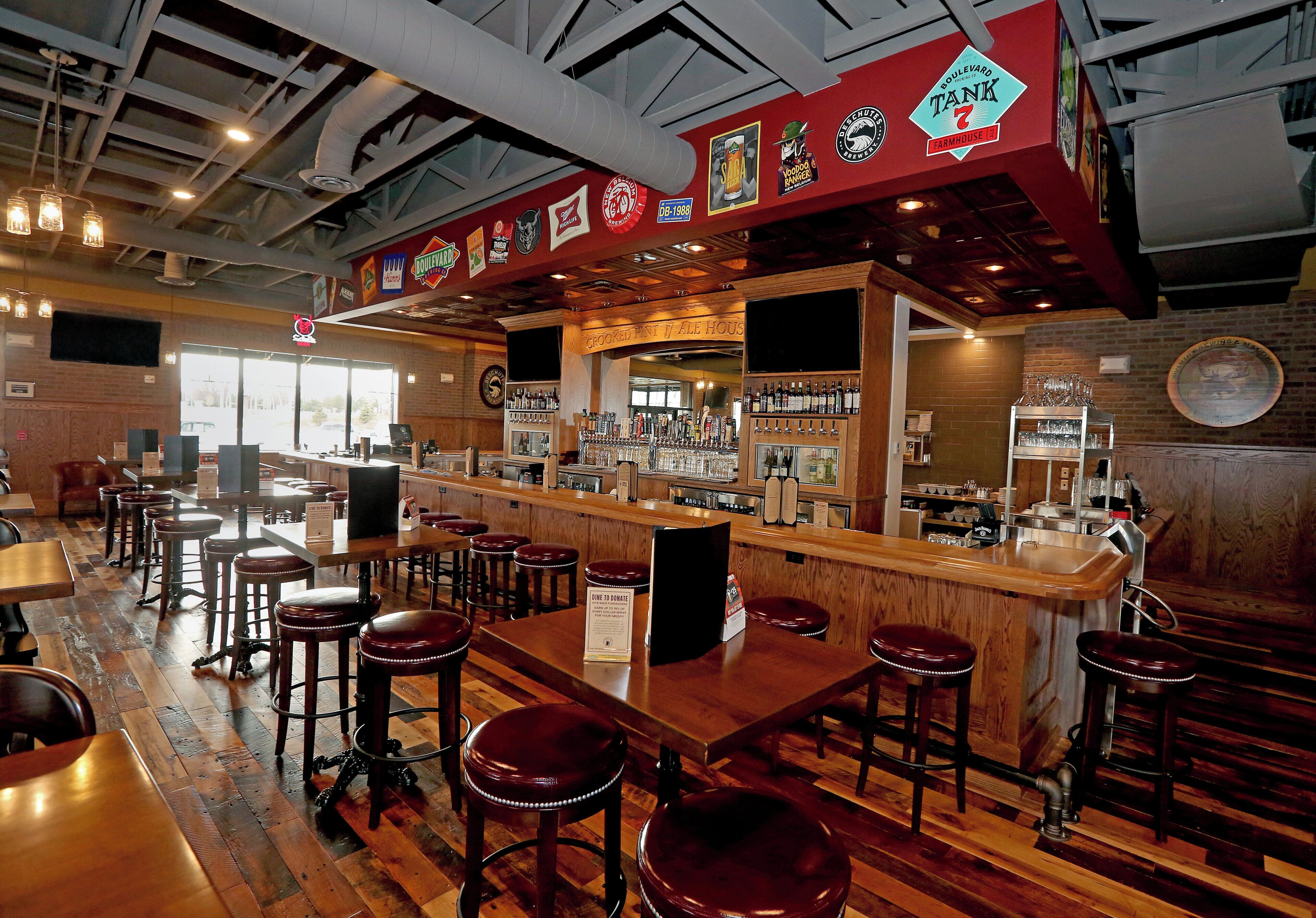 A bar area with stools, a counter, and various beer taps.