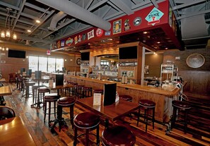 Un espace bar avec des tabourets, un comptoir et différents robinets à bière.