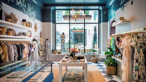 A boutique store with shelves of bags and clothing, a display table with accessories, and a view of the outside through large windows. - Perry Lane Hotel, A Luxury Collection Hotel, Savannah (Savannah)