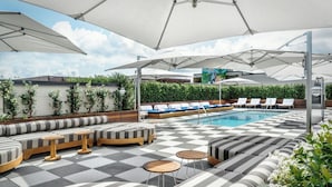 A rooftop pool area with striped seating, umbrellas, and a checkered floor. - Perry Lane Hotel, A Luxury Collection Hotel, Savannah (Savannah)