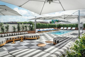 A boutique store with shelves of bags and clothing, a display table with accessories, and a view of the outside through large windows. at Perry Lane Hotel, A Luxury Collection Hotel, Savannah