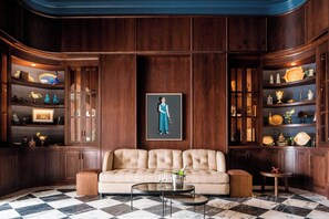 A luxurious living room with a checkered floor, a plush sofa, and wooden paneling.