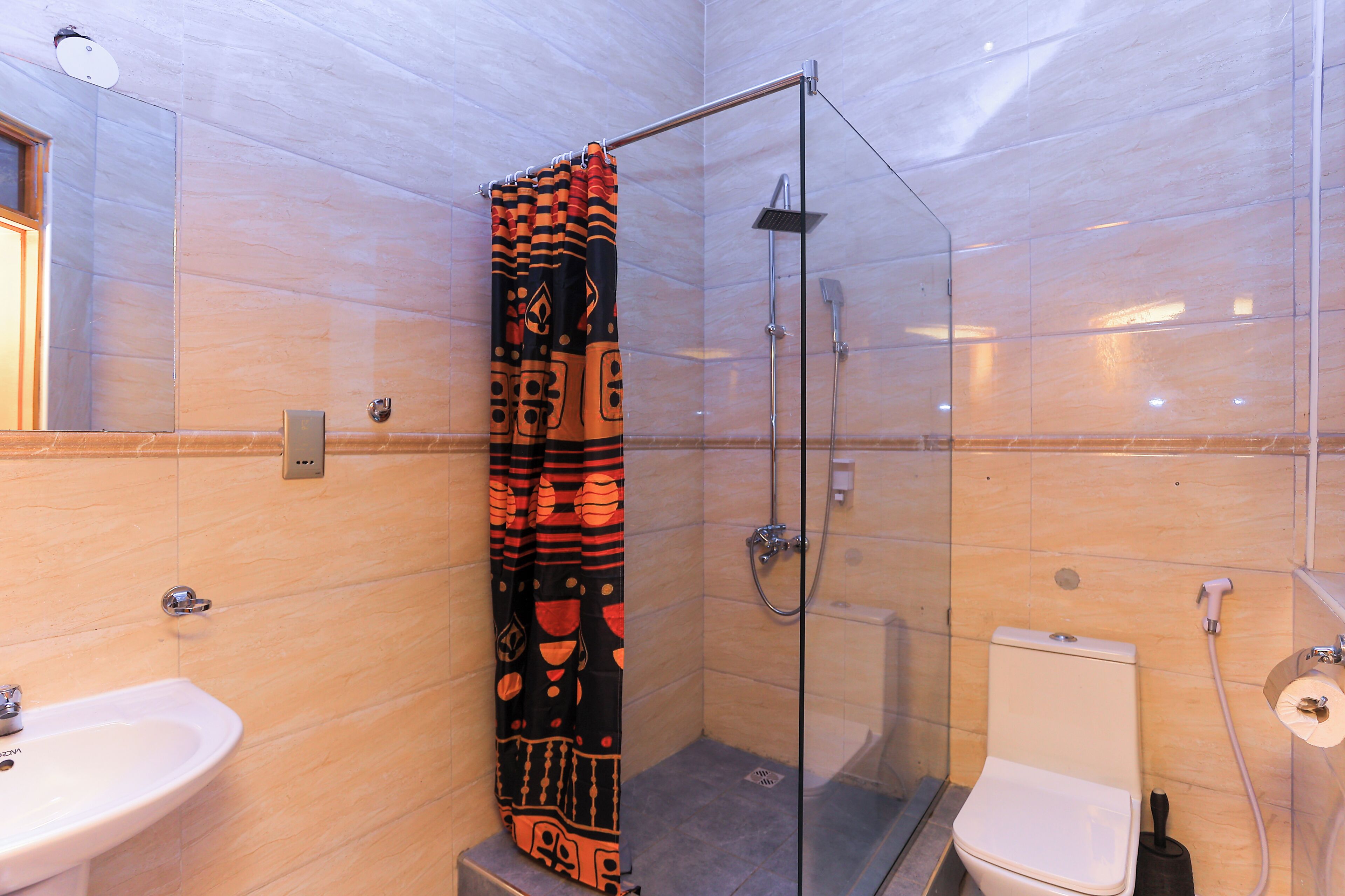 Une salle de bain avec une douche à parois de verre, des toilettes et un lavabo.