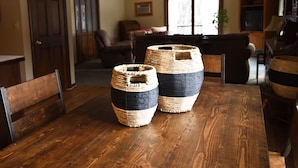 A dining area with a wooden table and two woven baskets. - Timber Inn Motel (Ludlow)