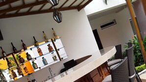 Uma área de bar com balcão e assentos de madeira.