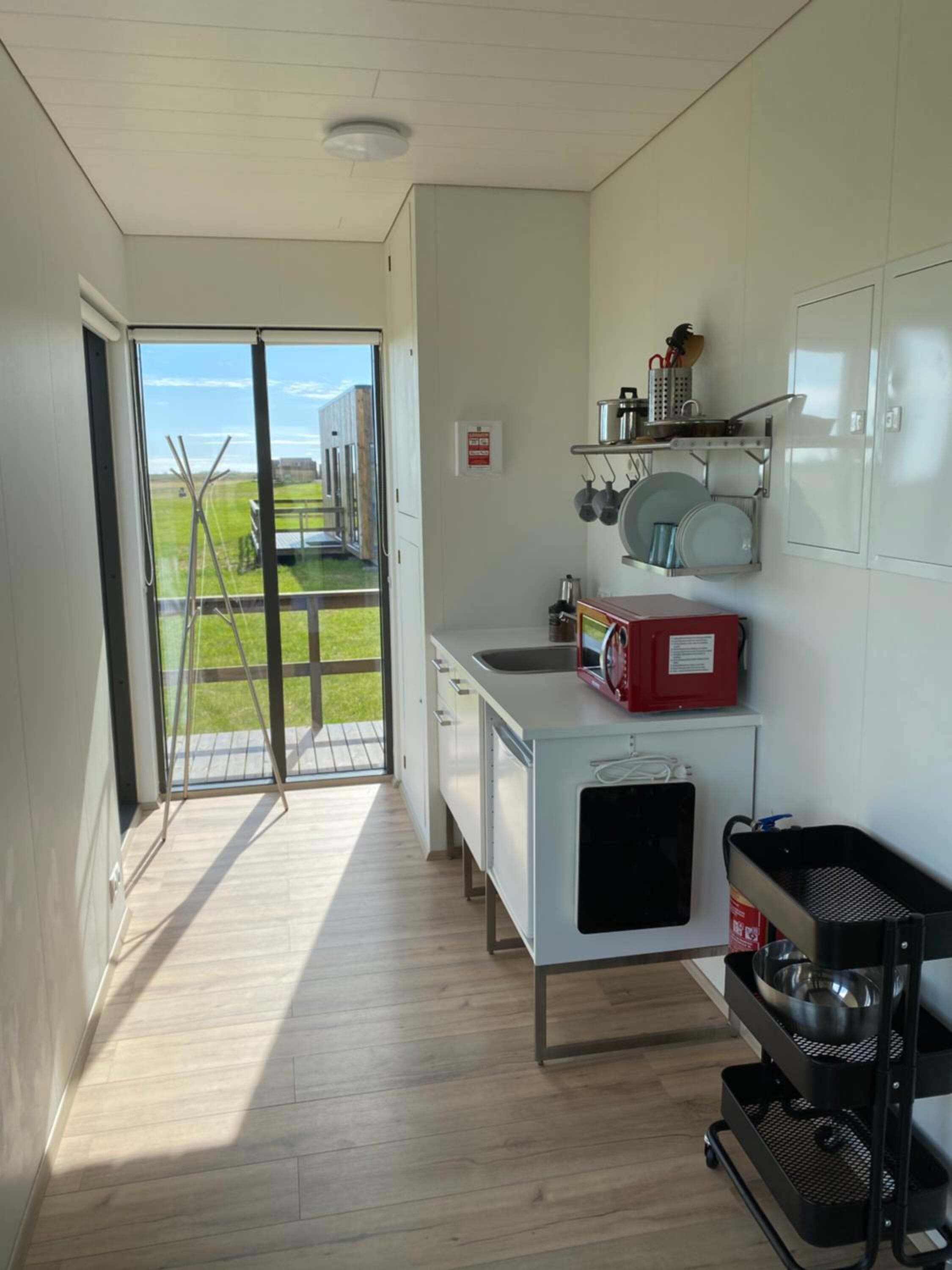 Una cocina con vista a un campo verde y un edificio a lo lejos.