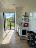 Una cocina con vista a un campo verde y un edificio a lo lejos.