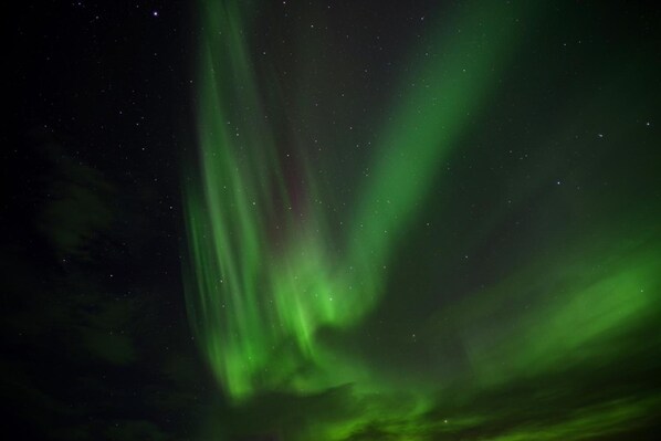 A night sky with visible stars and green aurora borealis. - Brú Guesthouse (Rangárþing eystra)