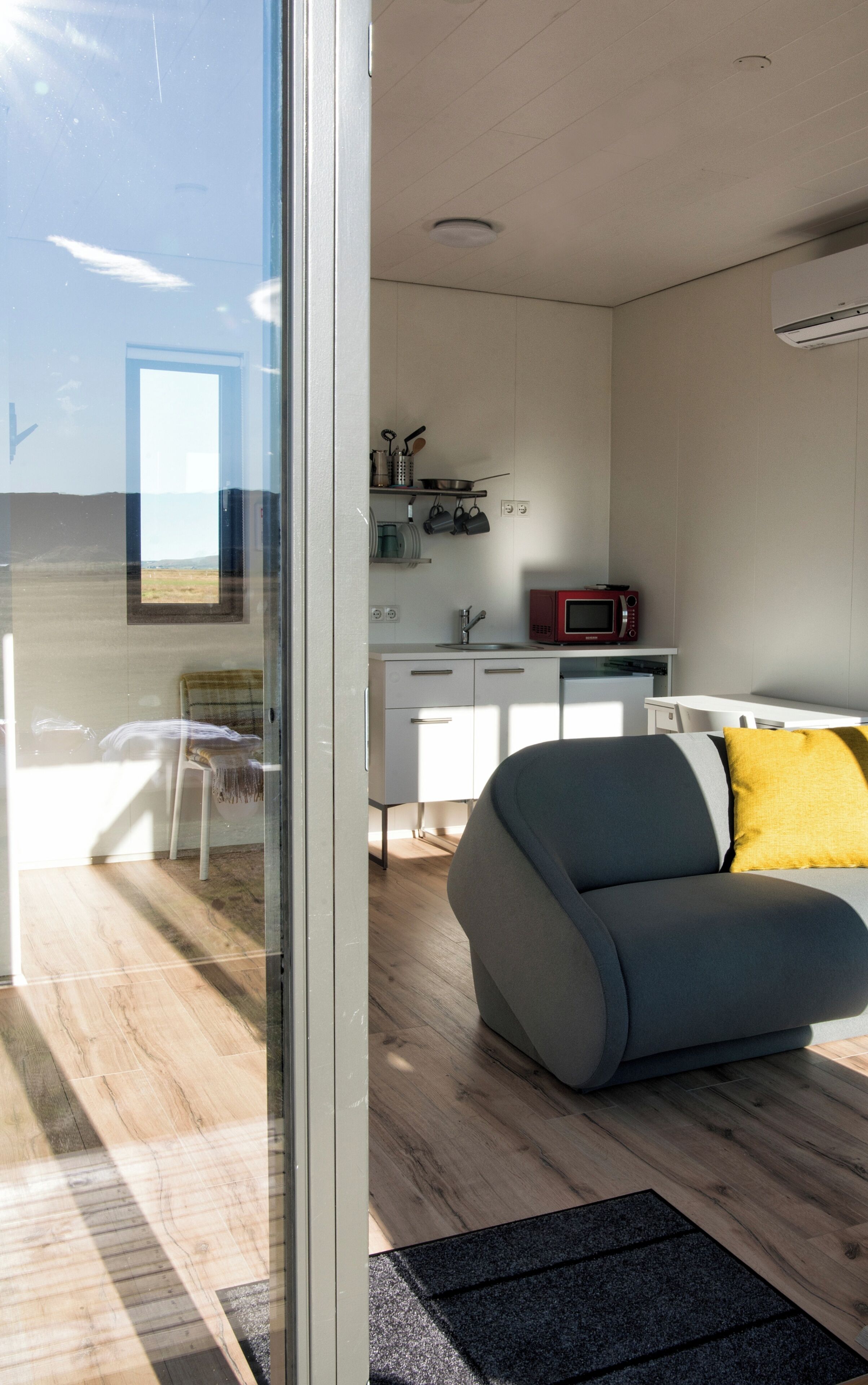 Un interior moderno con un sofá, una mesa de comedor y una zona de cocina.