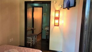 A hotel room with a bed, a desk, and a television. - Residenciais Gramado House (Gramado)
