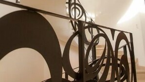 Un escalier en colimaçon orné de rampes en métal ouvragé.