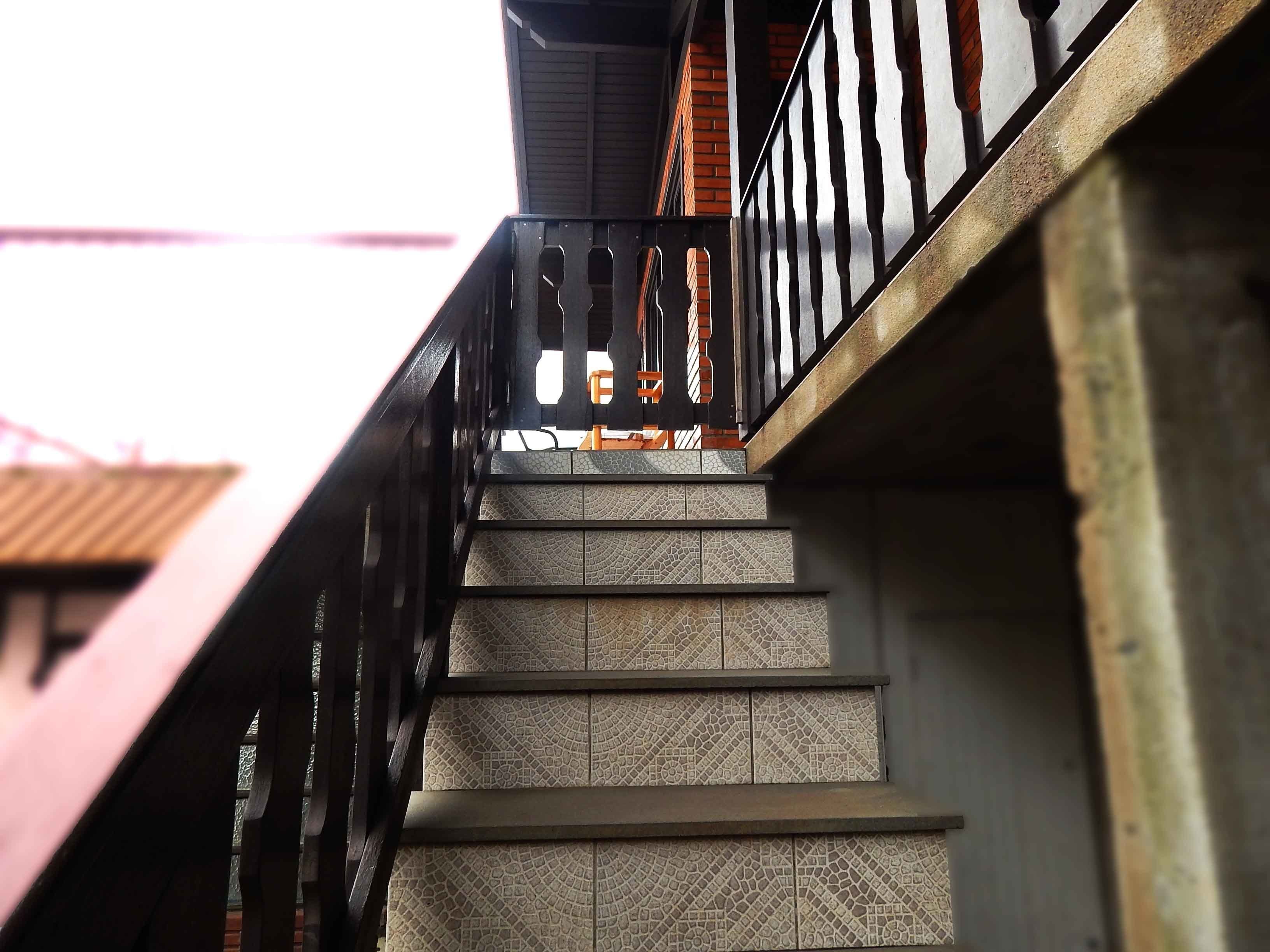A staircase with patterned tiles and a metal railing.