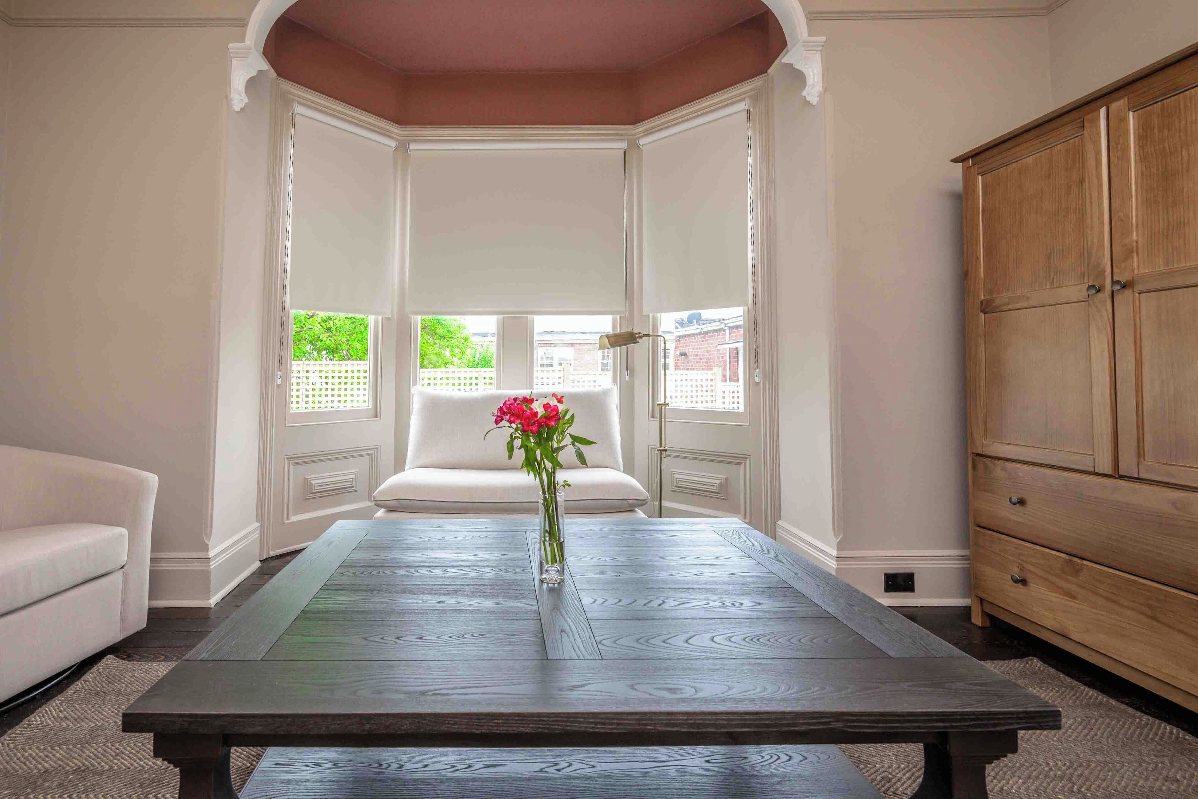 Une pièce avec une grande table en bois, un canapé blanc et un meuble en bois.