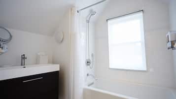 A modern bathroom with a white vanity, a bathtub, and a shower.