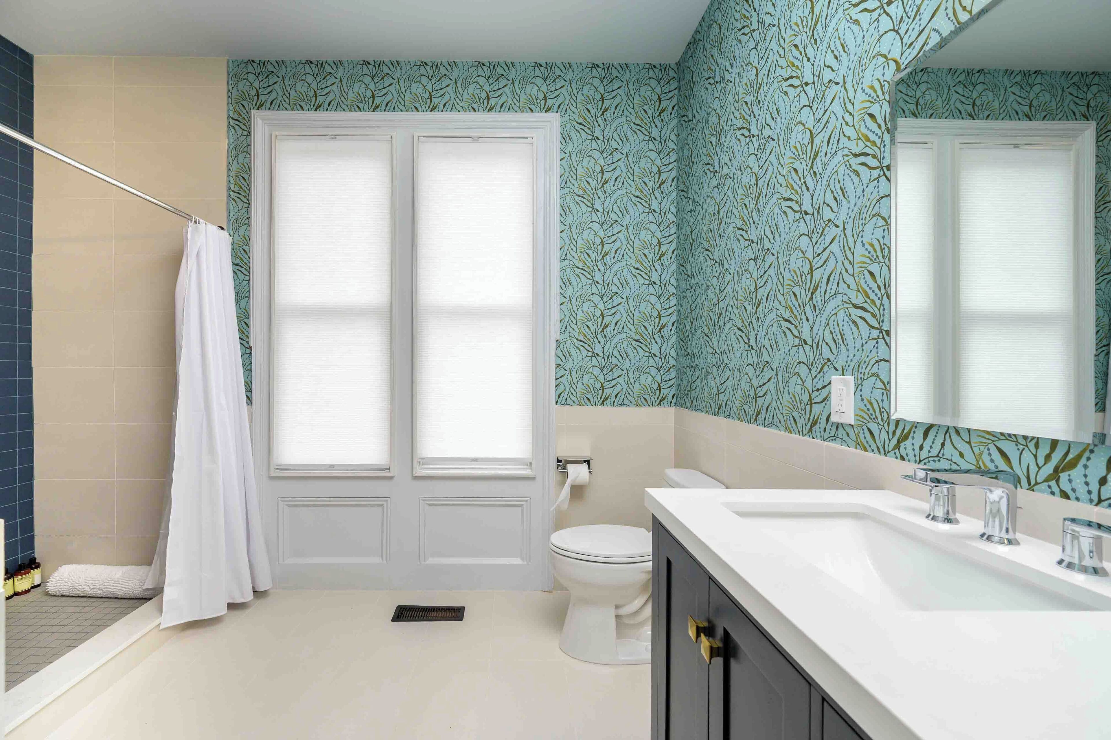 A bathroom with a white toilet, a white sink with chrome fixtures, and a shower area with a white curtain.
