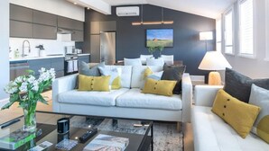 A modern living room with a sofa, coffee table, and a dining area with a table and chairs. - Station Inn Pawling (Pawling)