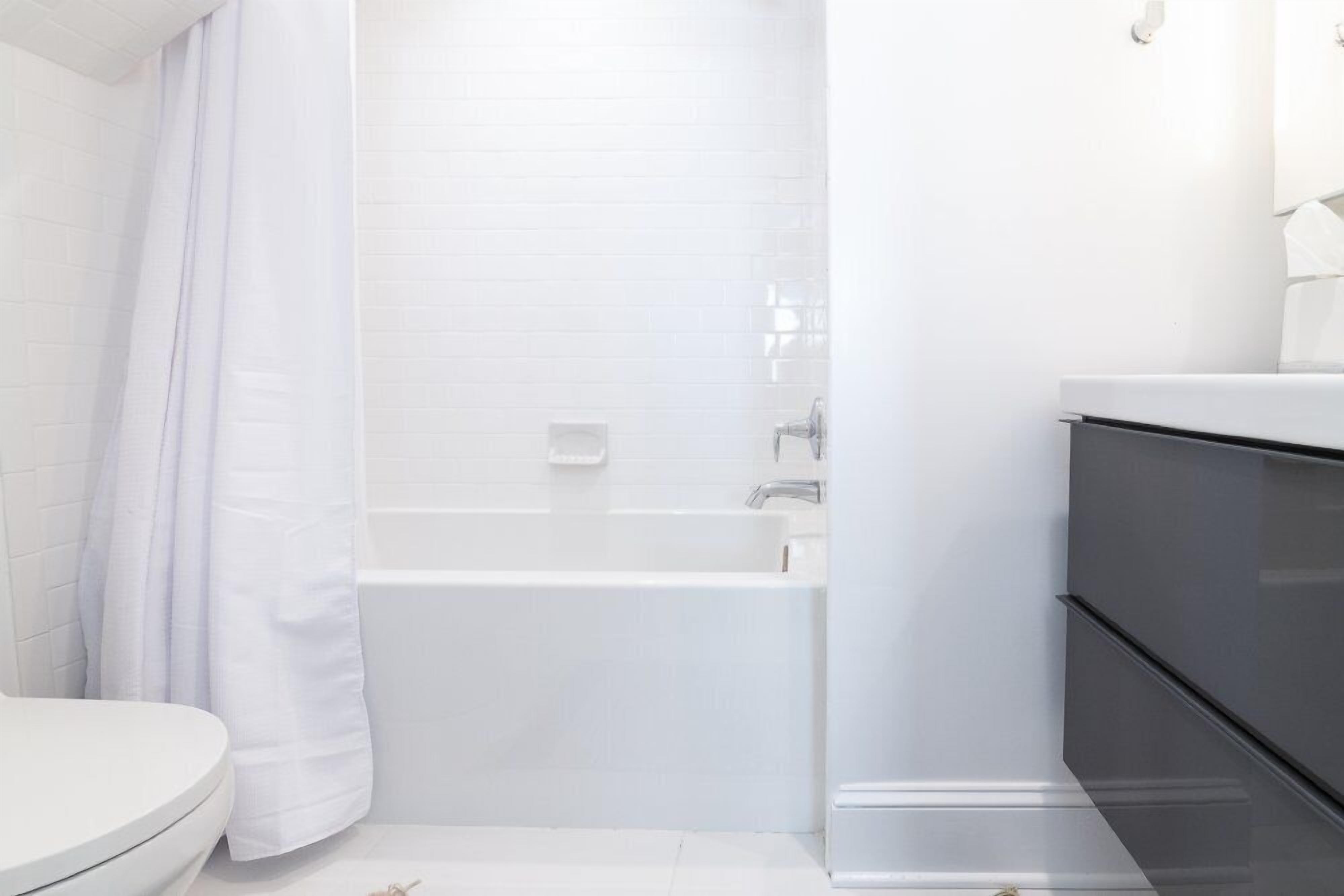 Un baño moderno con una bañera blanca, un inodoro y un lavabo.