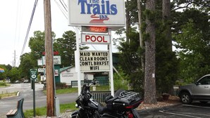 A motel sign with amenities including a pool, maid service, and WiFi.