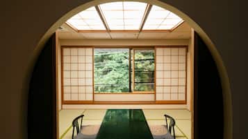 A traditional Japanese room with tatami flooring, a low table, and sliding shoji doors.