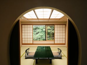 A traditional Japanese room with tatami flooring, a low table, and sliding shoji doors. - Syoenso Hozugawatei (Kameoka)