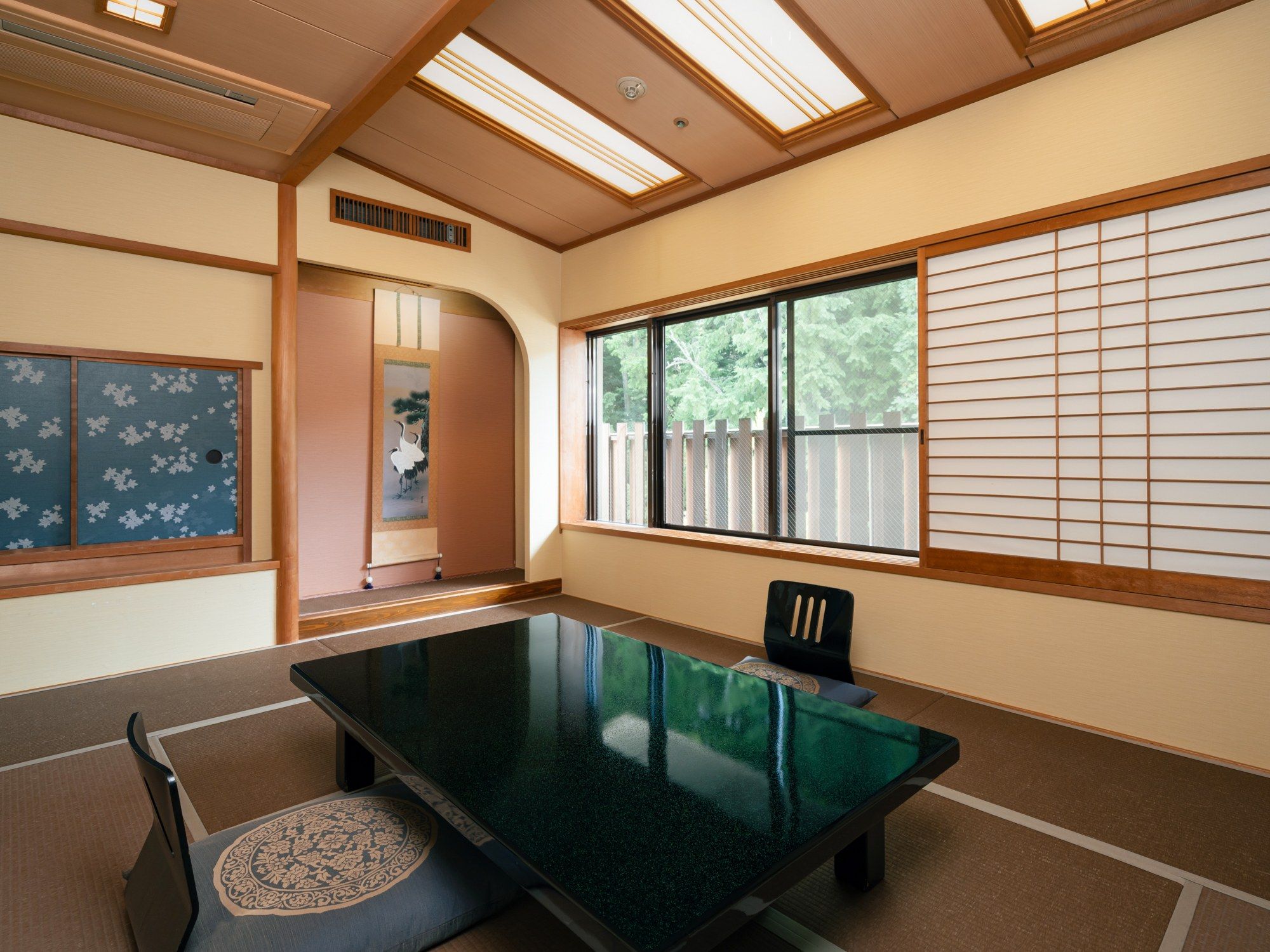 Una habitación tradicional japonesa con suelo de tatami, una mesa baja y puertas correderas shoji.