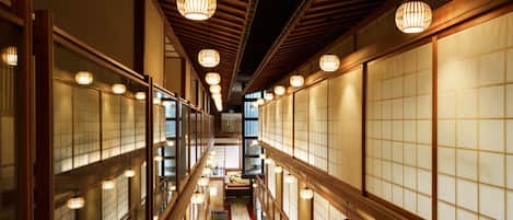 Un couloir doté de portes coulissantes traditionnelles japonaises et de poutres en bois.