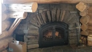 A stone fireplace with a log shelf, a wooden ceiling, and a rustic interior. - Authentic Hand-Crafted Mountain Cabin w/ Amazing Lake View ! (Somers)