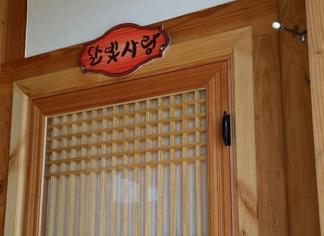 Una porta di legno con una finestra a griglia e un cartello sopra.