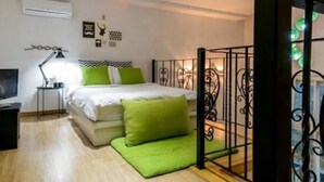 A bedroom with a bed, a nightstand, a lamp, and a window with decorative elements. - Emotion Pension (Hadong)