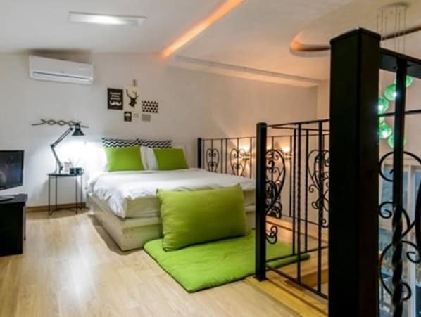 A bedroom with a bed, a nightstand, a lamp, and a window with decorative elements.