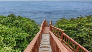 Un escalier en bois mène à un point de vue d’où l’on peut admirer l’océan.