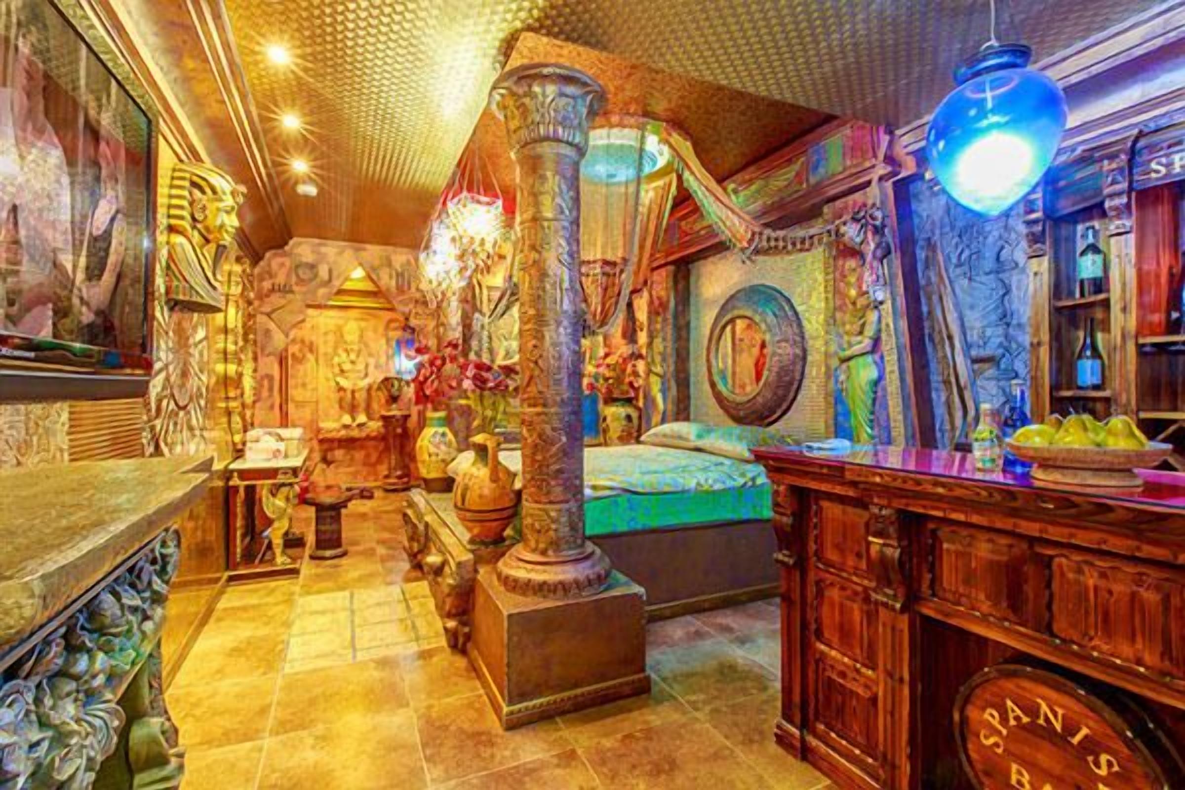 A room with a bed, a wooden cabinet, and a large vase.