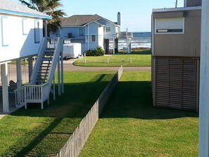 A residential property with a covered porch, a staircase, and a view of the ocean.