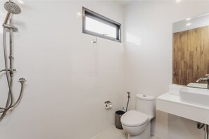 Un baño moderno con ducha, inodoro y lavamanos.