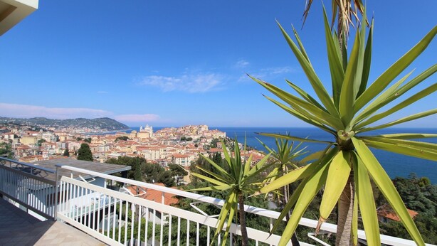 A balcony with a view of a coastal cityscape, including a prominent building and the sea. - Beautiful apartment in Imperia Porto Maurizio, best panoramic area of the city (Imperia)