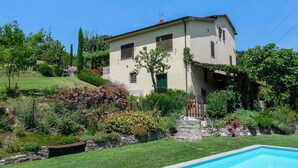 A two-story house with a swimming pool, surrounded by lush gardens and a hillside. - Beautiful villa, private pool WIFI gorgeous gardens & mountain views- peaceful! (Poggio)