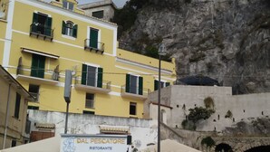 Un edificio amarillo con un letrero que dice "Dal Pescatore Ristorante" y una verja azul.