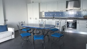 Una cocina moderna con gabinetes blancos, un salpicadero de azulejos azules, una estufa a gas y un horno empotrado.