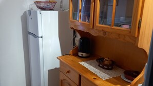 A compact kitchen with a white refrigerator, wooden cabinets, and a small countertop. - African reserve Sigean 15 mn, beach 200 m, Le Mieukerien (Port-La-Nouvelle)