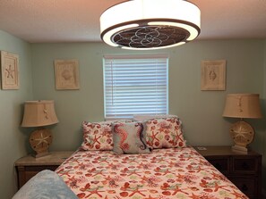 A bedroom with a bed, two nightstands, a ceiling fan, and a window with blinds. - GREAT LOCATION WATERFRONT, HEATED POOL! BEAUTIFUL SUNSETS, ALL PETS STAY FREE! (Holiday)