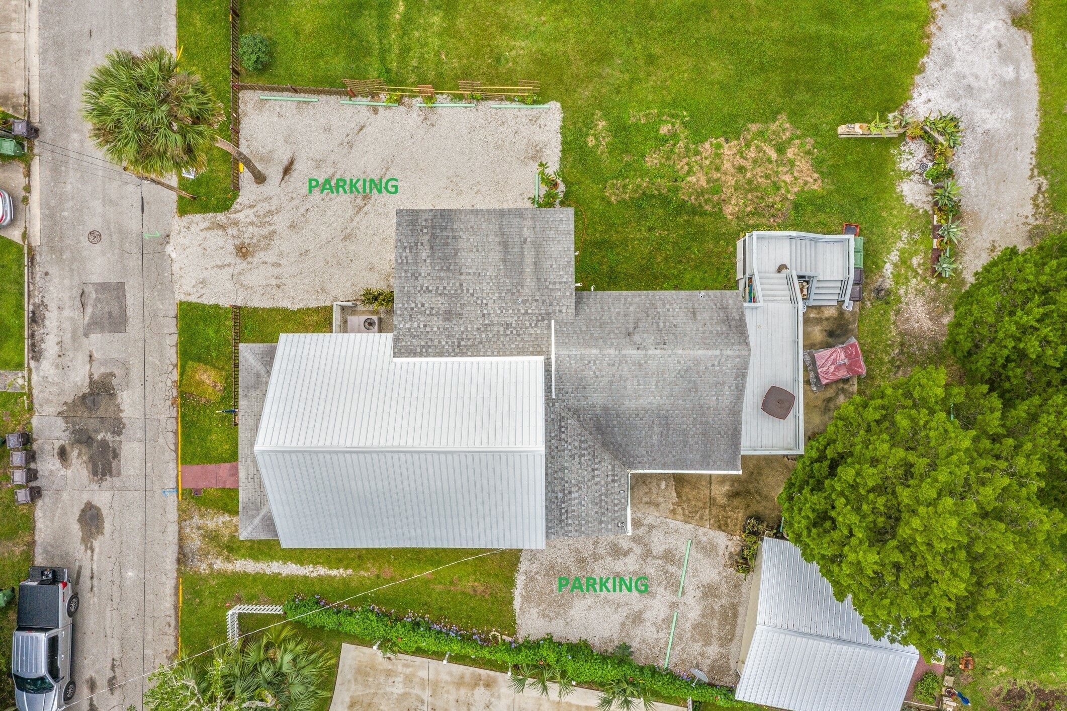 Vue aérienne d’un bâtiment doté de deux aires de stationnement signalées par la mention « PARKING ».