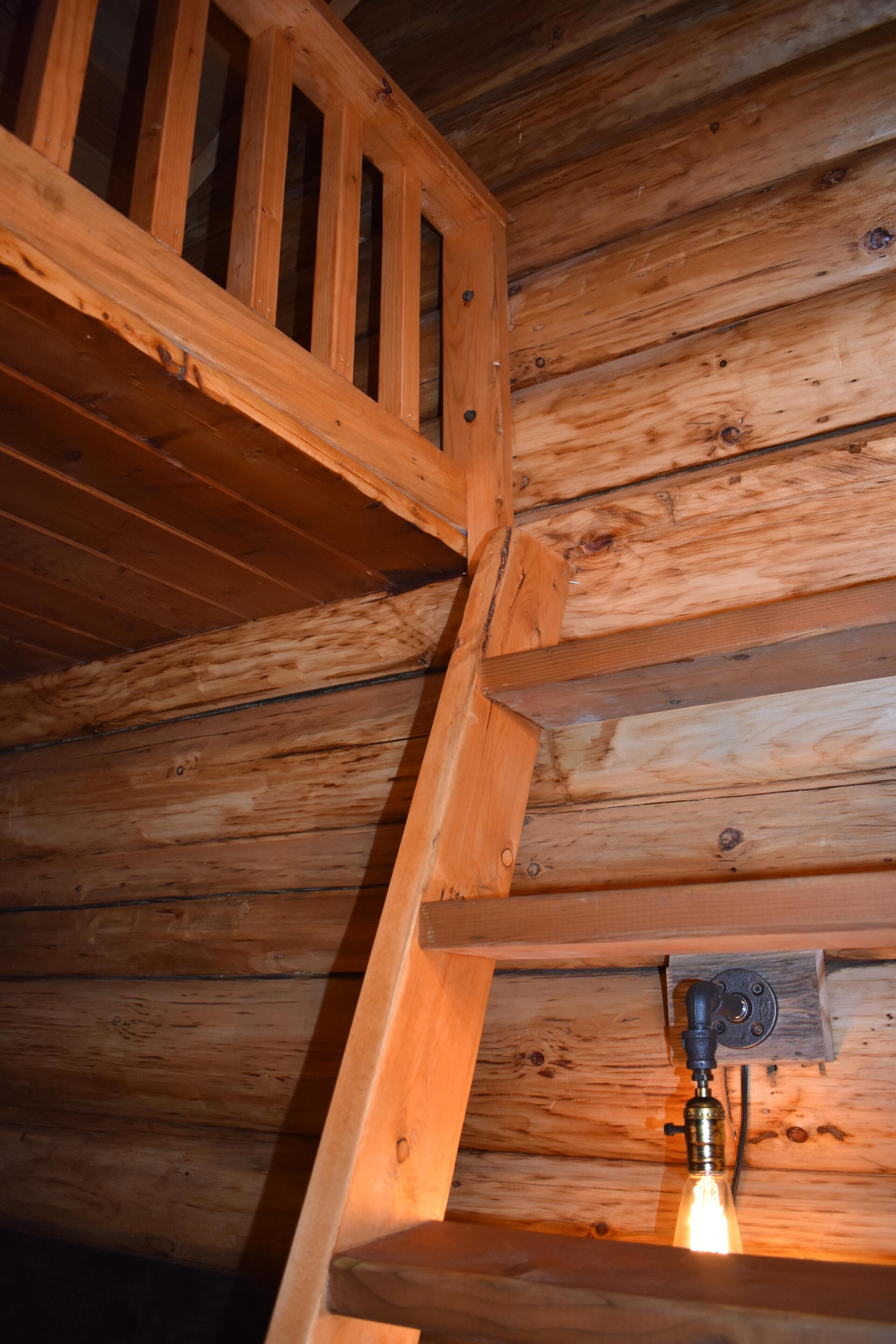 A wooden staircase with a light fixture at the bottom.