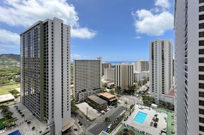 A high-rise building with a rooftop pool and a view of the ocean. - Partial Ocean View, one-bedroom with AC, Wi-Fi, parking, short walk to beach! (Honolulu)