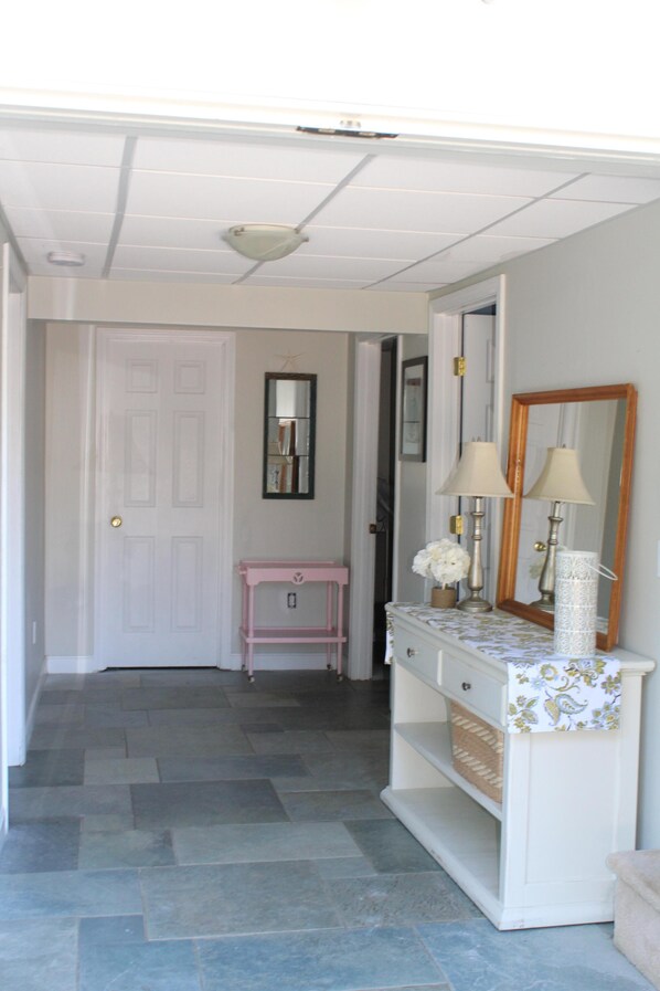 A hallway with a white door, a pink vanity, and a mirror. - Beach Cottage 1 Mile From Weekapaug & Misquamicut (Westerly)