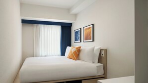 A hotel room with a bed, a desk, and a window with curtains. - Four Points Flex by Sheraton Morioka (Morioka)