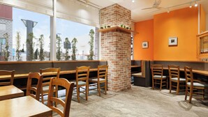 A restaurant with brick walls, wooden tables, and chairs. - Four Points Flex by Sheraton Morioka (Morioka)
