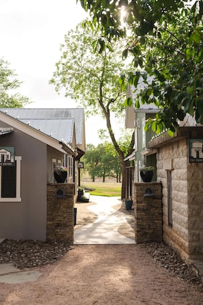 A pathway leading to a building with a stone facade and a sign that reads 'The Cottage.' - Romantic Fredericksburg Cottage w/ Hot Tub (Fredericksburg)