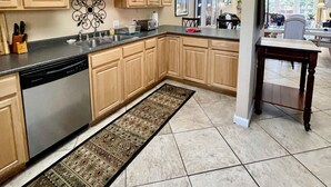 A spacious kitchen with wooden cabinets, a dishwasher, and a large island. - Sandia Heights #1 rental (ALBUQUERQUE)
