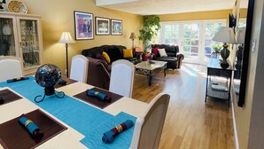 A dining area with a table set for four, a sofa, a coffee table, and a lamp. - Sandia Heights #1 rental (ALBUQUERQUE)