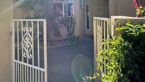 A courtyard with a gated entrance, a small window, and a door. - Sandia Heights #1 rental (ALBUQUERQUE)